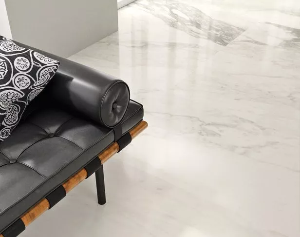 White marble look tiled floor with black vinyl sitting chair and black and white pillow