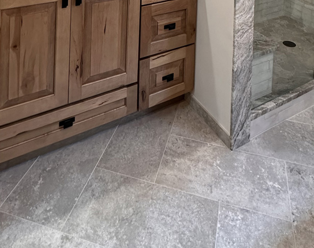 Gray cement look tiled bathroom floor with rustic wood vanity