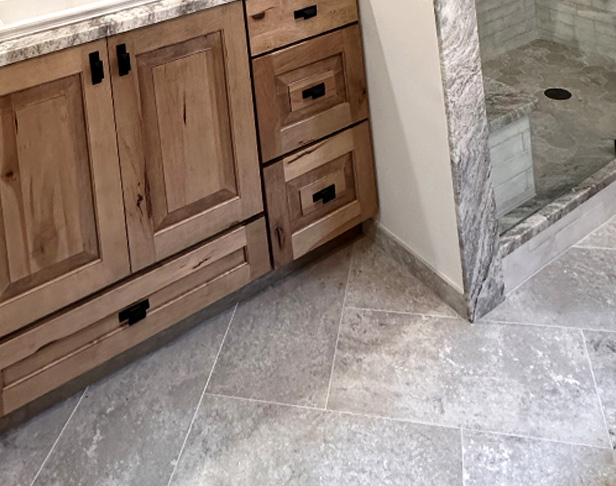 Gray cement look tiled bathroom floor with rustic wood vanity