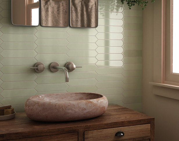 pale green glossy picket shaped tiled bathroom backsplash with rustic wood vanity, oval chisled stone sink, and mirror