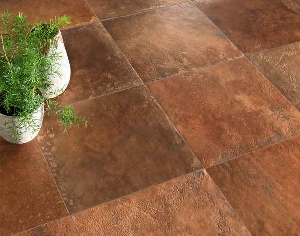 Terracotta porcelain square tiles installed on a floor with plants in white planters