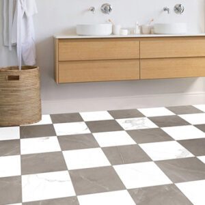 Gray and white marble-look checkerboard pattern tiles in a modern bathroom with blonde wood sink vanity and wicker hamper