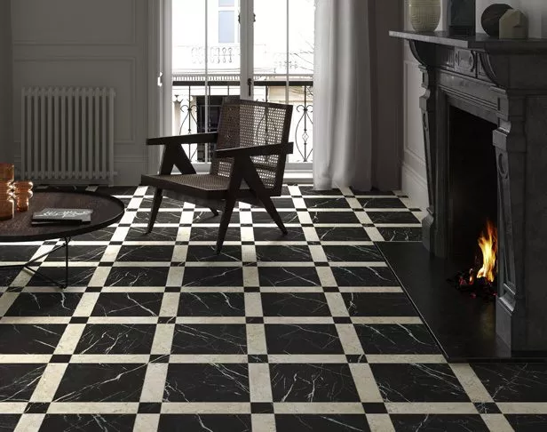 checkerboard and grid patterned black and white marble tile floor with a chair next to a fireplace