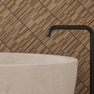 Batik patterned wall and floor tiles on a bathroom wall with a marble soaking tub and floor mount bronze tub filler