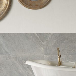 Gray marble tiled bathroom wall with white clawfoot tub and gold fixtures