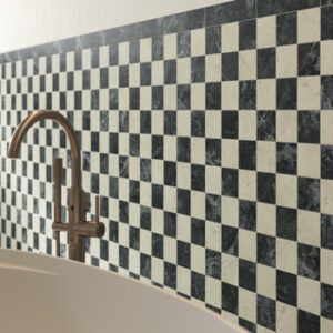 Ivory and dark green marble look tiles in a checkerboard pattern on a bathroom wall behind a tub