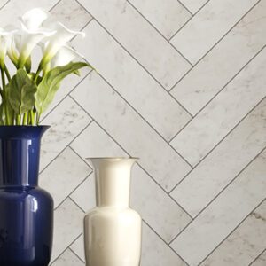 White 3x12 marble look tiled kitchen backsplash with blue vase filled with white lillies