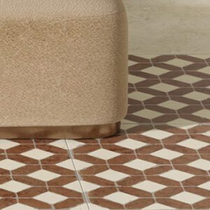 Red and white marble tile in a lattice pattern on a floor with beige ottoman