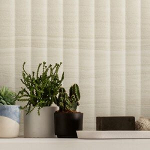 Beige striated fluted wall tile with small potted catcti plants