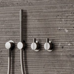 dark gray grooved wall in a shower with stainless steel fixtures