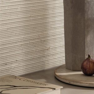 light gray grooved wall with book, cutting board,vessel, and fig