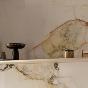 Large format white, black, and gold marble look tiled kitchen backsplash with shelf