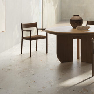 White cement-look tiled kitchen floor with brown table and chair