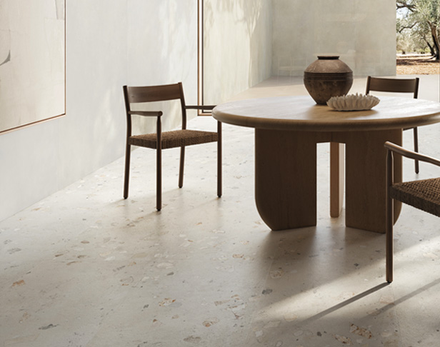 White cement-look tiled kitchen floor with brown table and chair