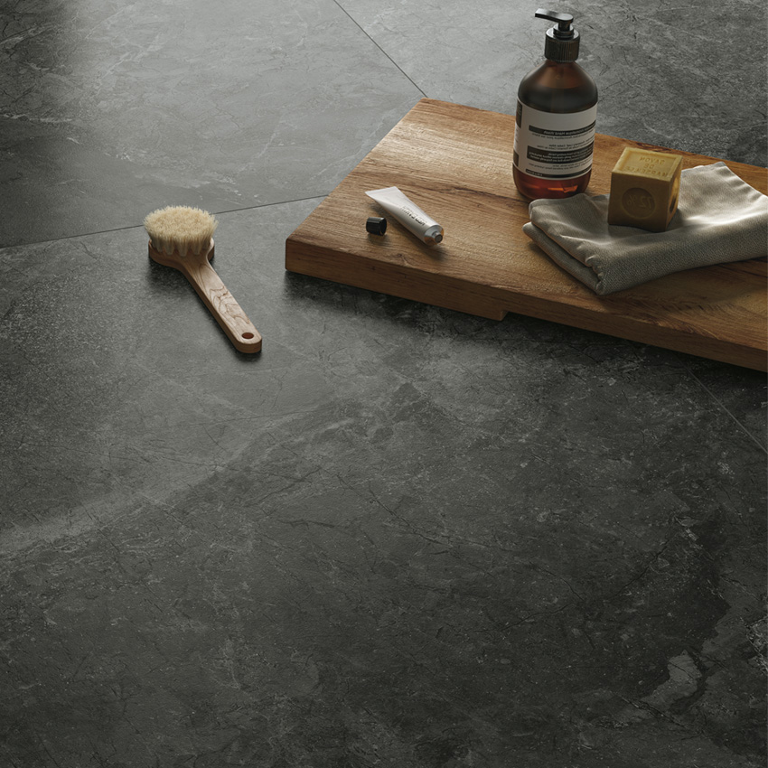 Black stone-look porcelain tiled floor with bath accessories