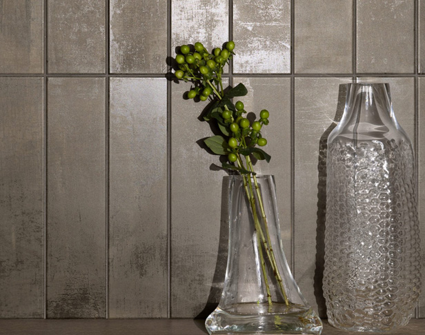 Gray metallic subway tiled wall installed vertically with glass bud vases