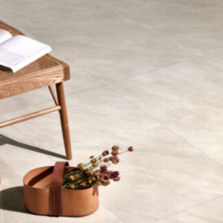 Beige onyx look porcelain polished tiled floor with rattan chair, book, and dried flowers