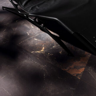 Black marble-look porcelain tiled floor with lounge chair