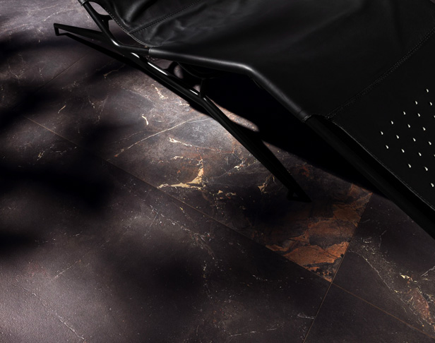 Black marble-look porcelain tiled floor with lounge chair