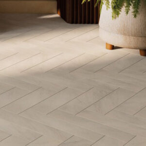 Beige marble look 4x16 tiled floor in a herringbone pattern