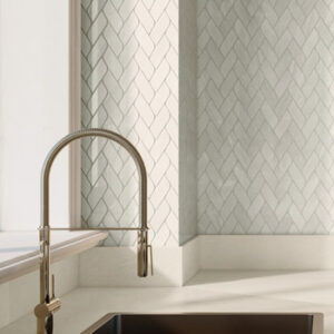 Beige Marble look braided mosaics on a kitchen backsplash with goose-neck faucet