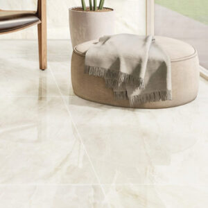 Beige marble look tiled floor with large round beige soft ottoman
