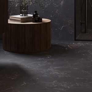 Black marble look tiled bathroom floors and wall with round accent table