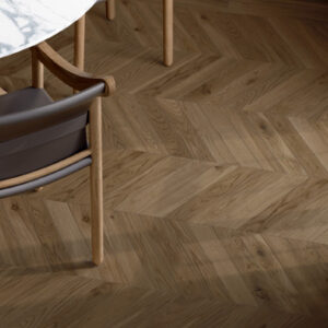 brown chevron tiles on a kitchen floor with carrara marble table and black chairs