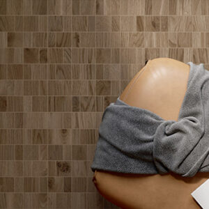 brown multi-sized square mosaic tiled floor with tan leather chair and gray throw blanket