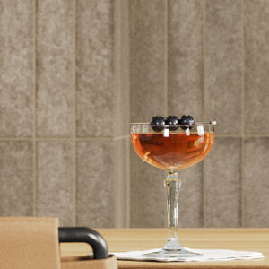 beige brick tiled wall with cocktail with berries