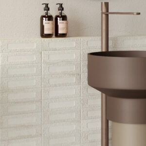 white brick tiled bathroom with modern bronze colored sink and faucet