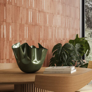 Terracotta colored brick tiled kitchen wall with light wood table and chair, green vase, and large plant