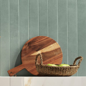green narrow tiled kitchen backsplash with cutting board and basket