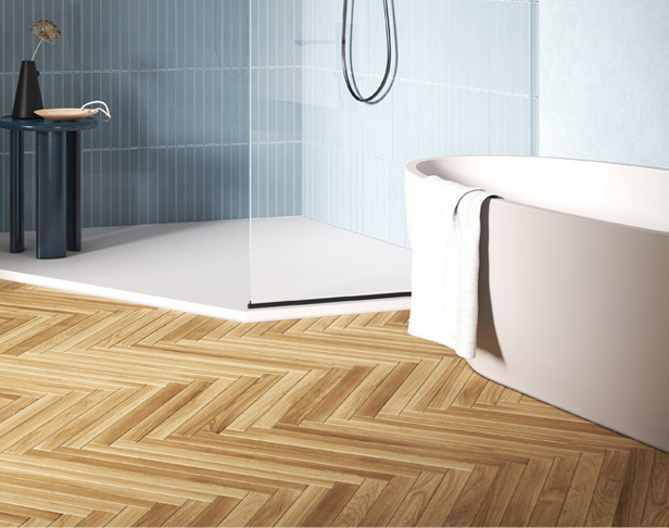 Honey beige wood look tiled bathroom floor in a herringbone pattern