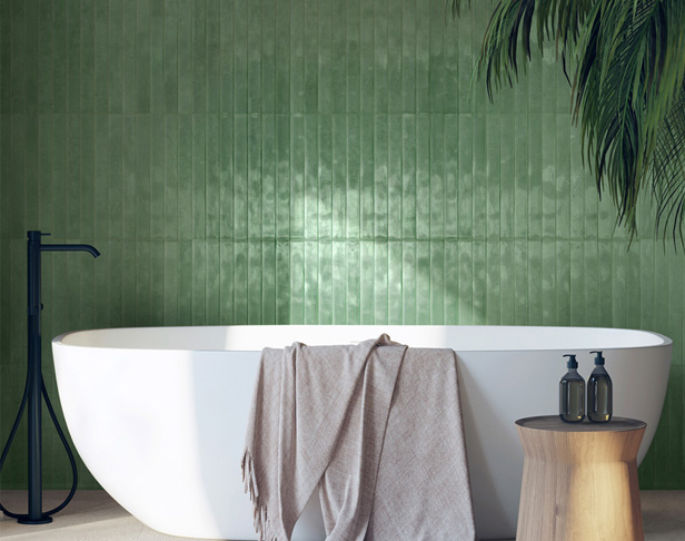 mint green glossy skinny brick tiles installed vertically in a bathroom with large soaking tub and towel