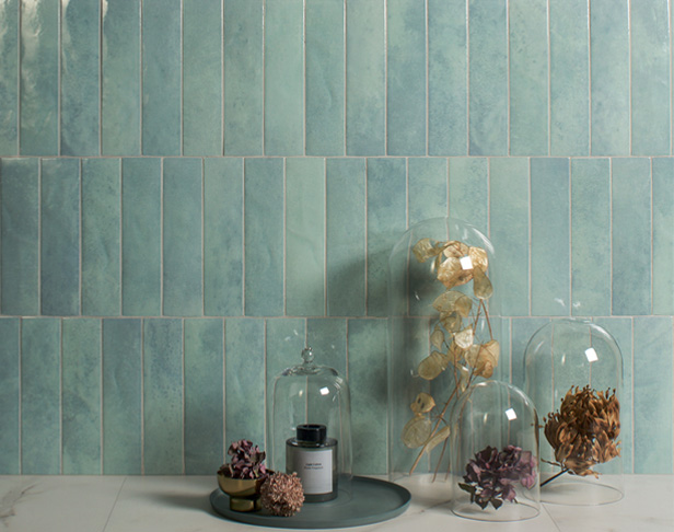 Aqua high-gloss tiled wall with glass domes filled with pinecones