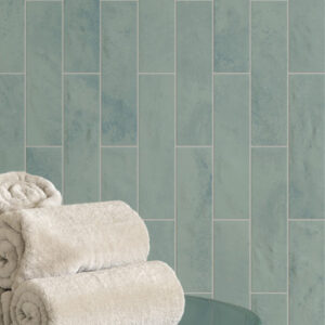 glossy aqua small format tiledd bathroom wall with rolled up white towels