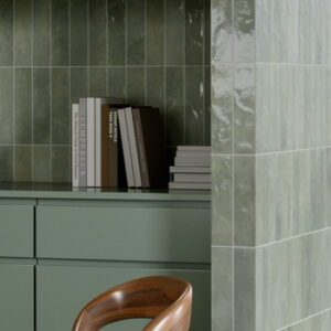 glossy green small format tiled kitchen backsplash with books and green cabinets