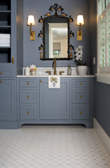 bathroom with wedgewood blue vanity with white marble countertop, gold fixtures, and white and blue square tiles on floor