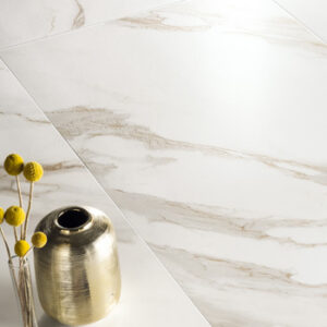 Calacatta gold look porcelain tiled floor closeup with gold vase