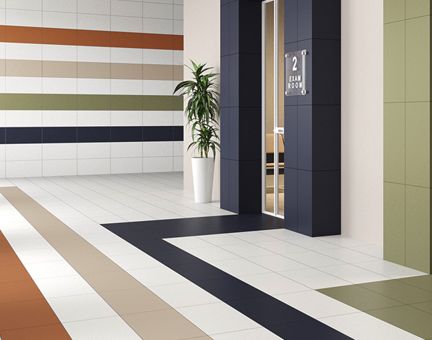White, beige, blue, sage green and terracotta colored 12x24 tiles installed walls and floors in a striped pattern of an office buildin