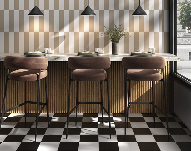 Beige and white rectangular tiles installed vertically on a cafe wall with black and white checkerboard floor tiles