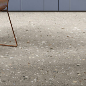 gray terrazzo look porcelain tiled kitchen floor with blue cabinets and copper wire leg chair