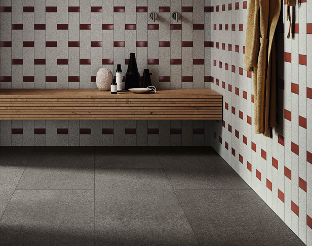Dark gray tiled shower floor with lighter gray and red glossy tiled walls